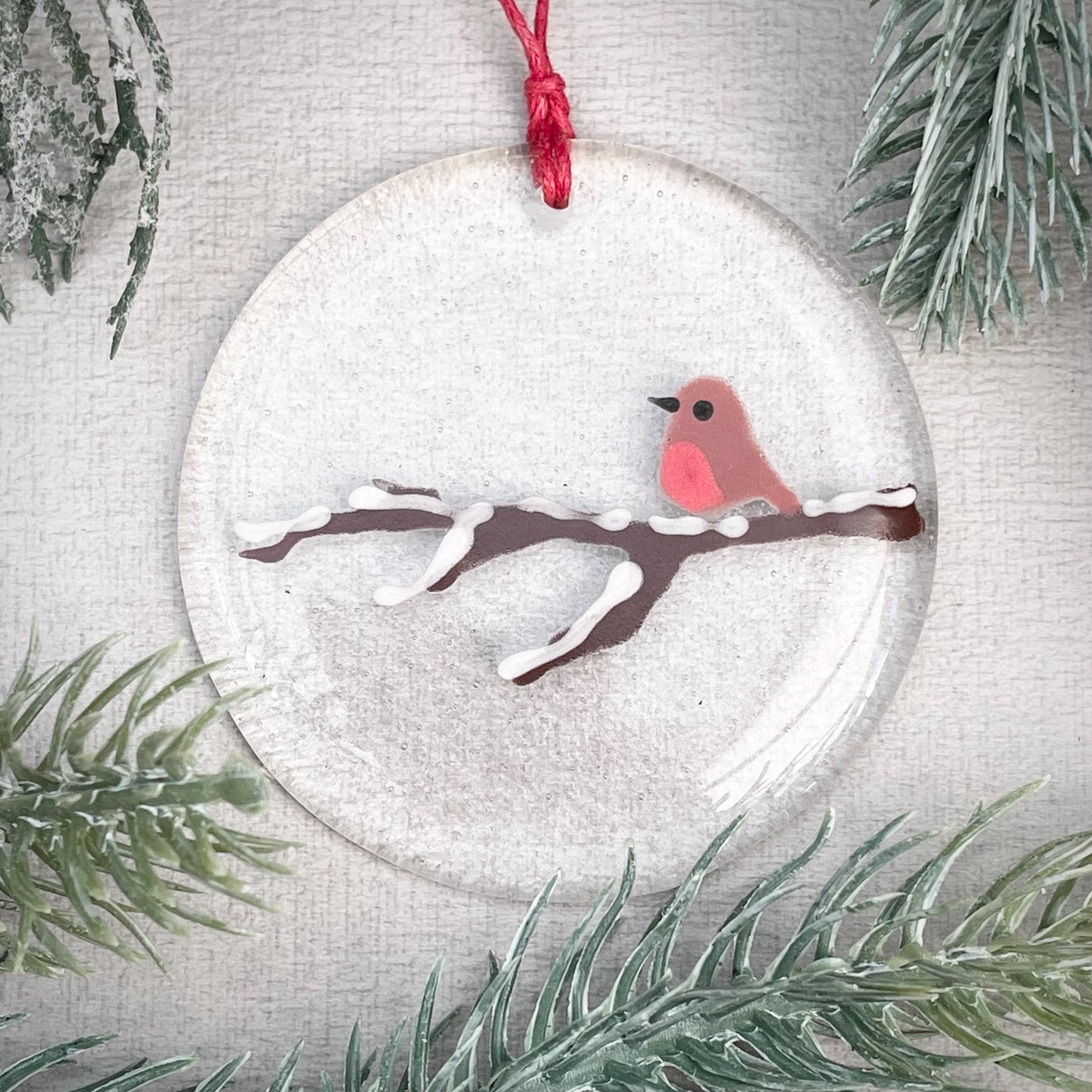Robin on a snowy branch - round hanger