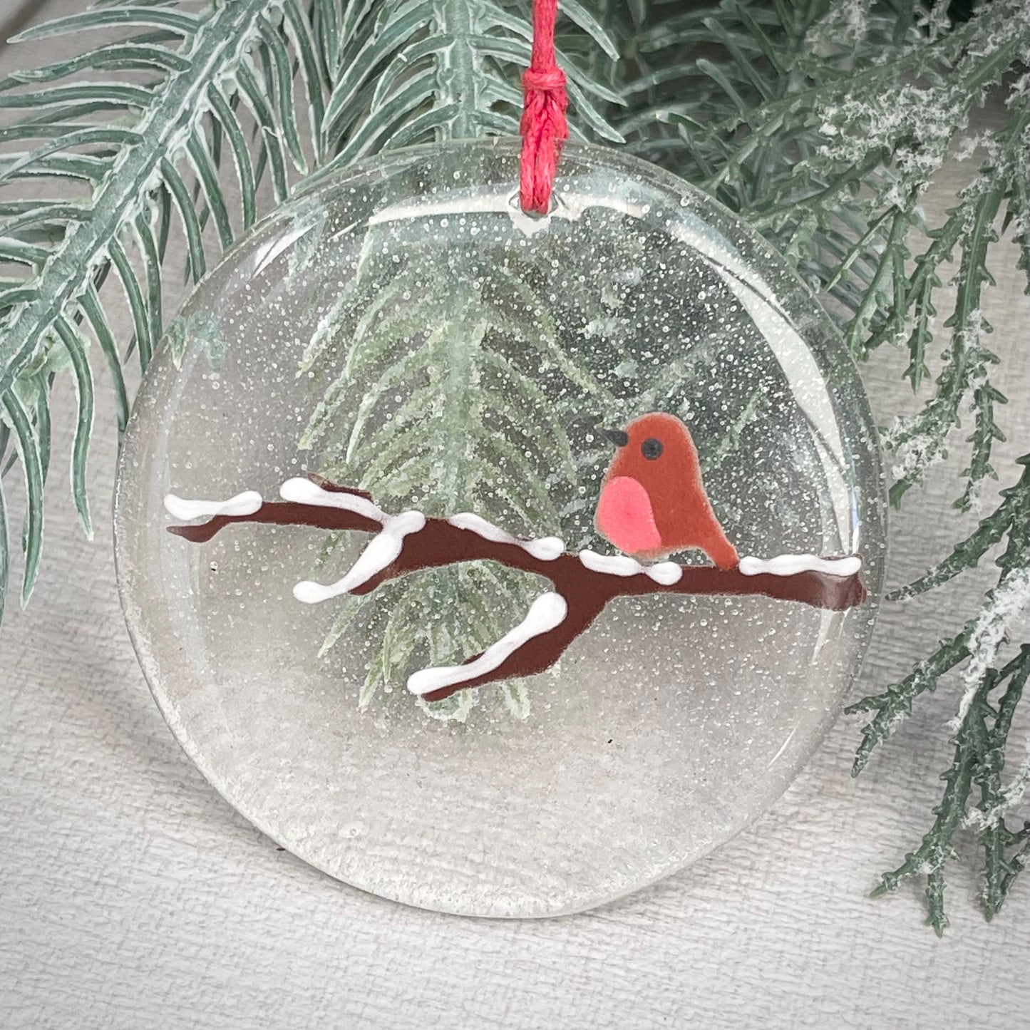 Robin on a snowy branch - round hanger